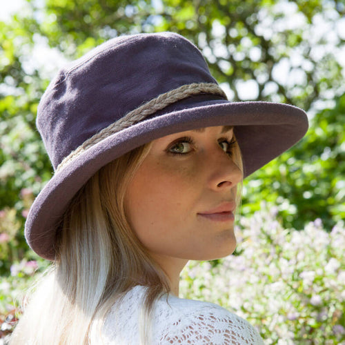 ladies aubergine coloured linen sun hat with natural cord round crown of hat on woman